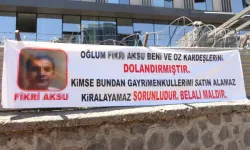 Oğlu tarafından dolandırıcılığını astığı pankartla duyurdu