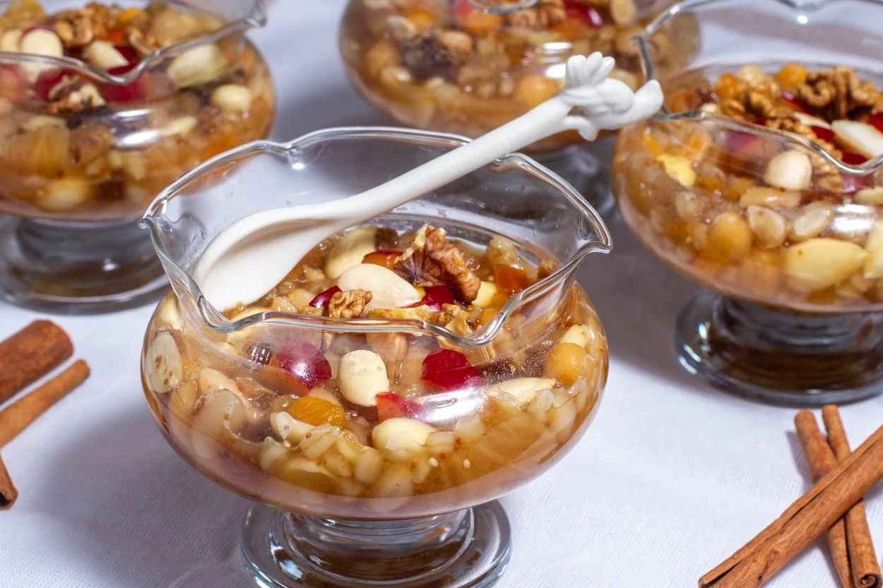 <p>6. Arada gerektikçe sıcak su eklemeyi ihmal etmeyin. Suyu azalan buğdaylarımıza biraz daha sıcak su ekleyelim.</p>
<p>7. Yaklaşık 50 dakika kadar kaynattığımız ve yumuşayan buğdaya yıkanmış pirinç, pişmiş nohut, haşlanmış fasulye, küçük doğranmış kayısı, incir ve kuru üzümünde suyunu süzerek ekleyelim ve 15 dk kadar kaynatalım.</p>
<p>8.Küçük bir cezve içerisine karanfil alalım ve suyu da ekleyerek 10 dakika kadar kaynamaya bırakalım.</p>
<p>9.Bu sırada suyu azalan buğdaylarımızın üzerine tekrar sıcak su ilave edelim.</p>
<p>10.Son olarak süzgeçten geçirdiğimiz karanfil suyu, fındık, sıcak süt, şeker, isteğe bağlı tuz, karabiber ekleyerek karıştıralım ve yaklaşık 15-20 dk daha kaynatalım.</p>